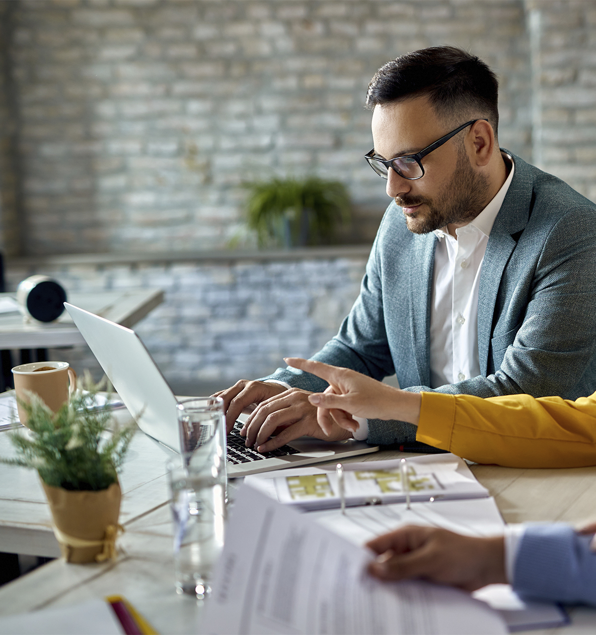 asesor-financiero-trabajando-computadora-mientras-reune-pareja-oficina