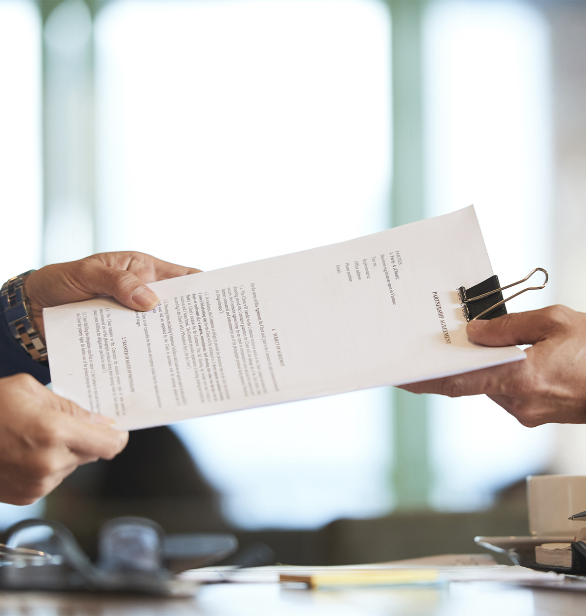 primer-plano-manos-pasando-contrato-al-empresario-irreconocible